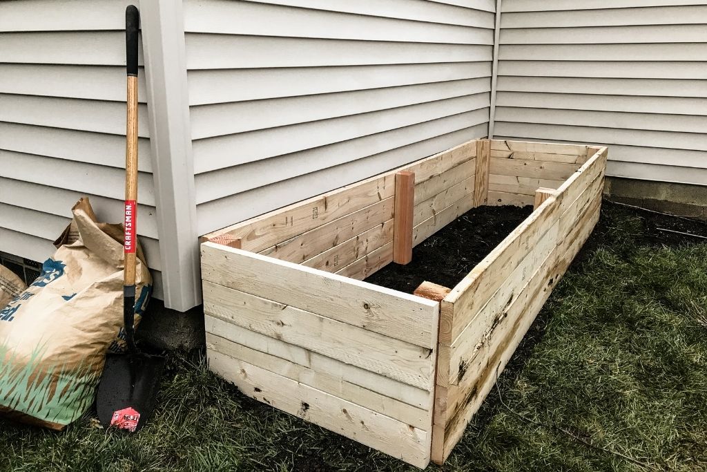 Image of a freshly built raised garden bed along the side of a house