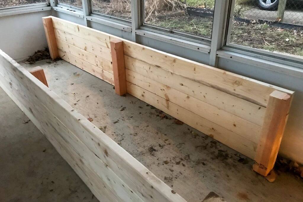 Image of a partially assembled raised garden bed. Two long sides stand across from each other.