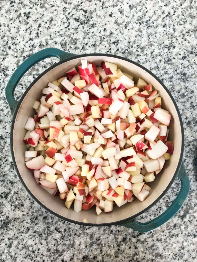 Overhead shots of chopped apples for applesauce in a dutch oven