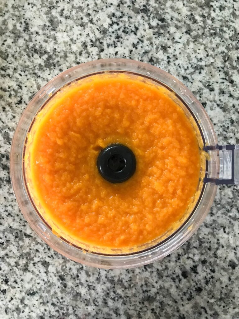 Overhead shot of a food processor full of fresh homemade pumpkin puree